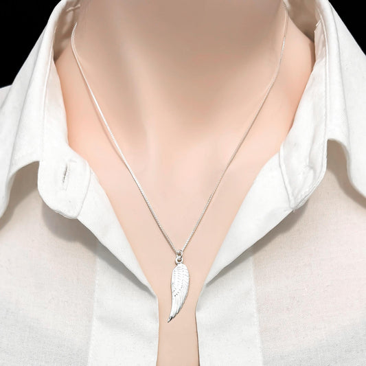 A silver necklace with a pendant featuring a wing design is shown against a white shirt collar.