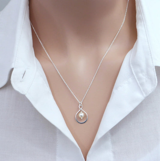 infinity and peach pearl necklace on a model mannequin