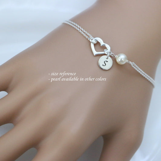 open heart and white pearl bracelet with initial charm on a model