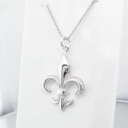 A silver-colored pendant necklace with a fleur-de-lis design.