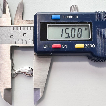 A digital caliper is being used to measure the size of a silver object, which appears to be a necklace. The caliper displays the size as 15.08 millimeters.