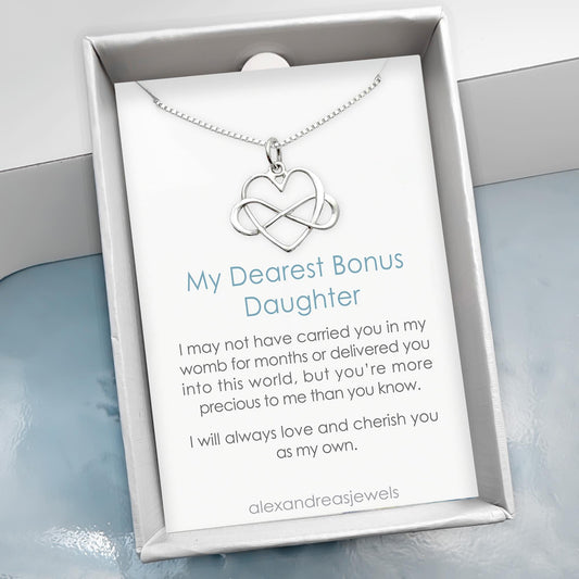 a silver necklace with a heart-shaped pendant, accompanied by a card that contains a heartfelt message about the mother-daughter relationship.