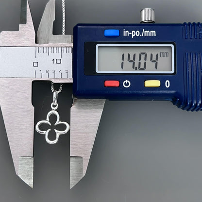 A silver flower pendant is being measured with a caliper, and the digital display shows the size of the pendant as 14.04 millimeters.