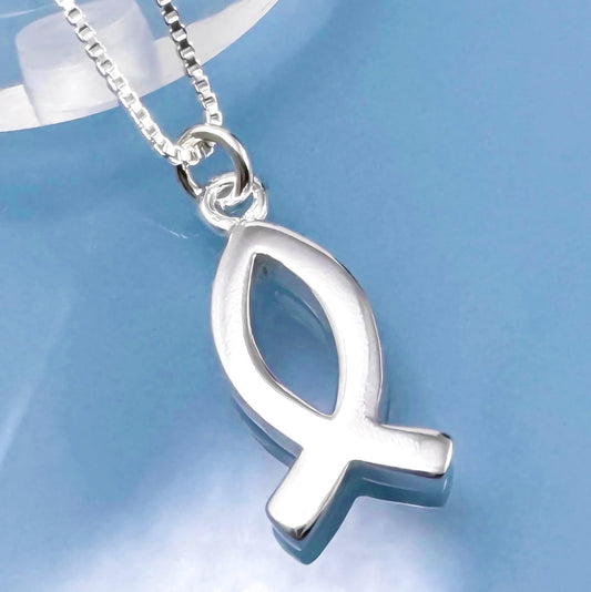 A silver fish-shaped pendant necklace with a chain is shown against a blue background.