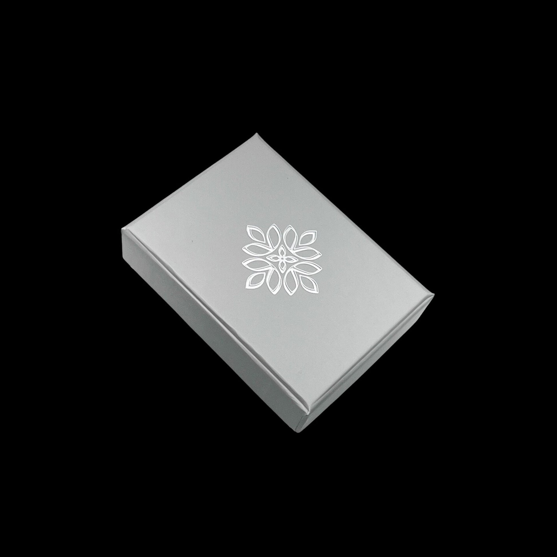 A white box with a floral design on it, placed against a black background.