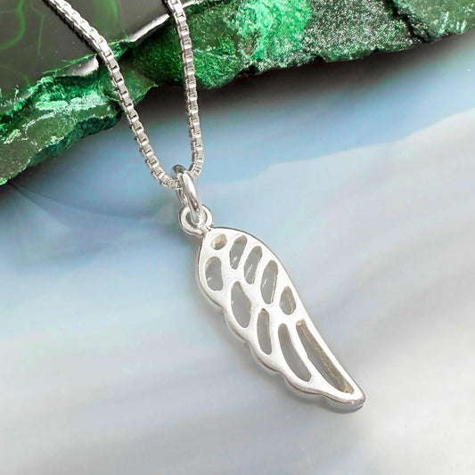 A silver-colored pendant in the shape of a wing is displayed against a green and blue background.