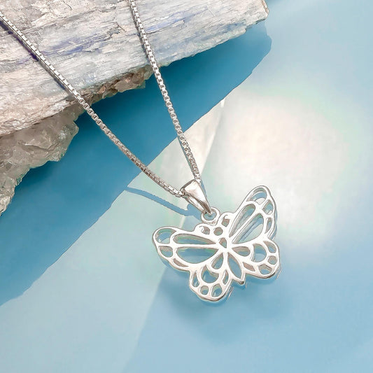 A silver butterfly pendant necklace is displayed against a blue background.