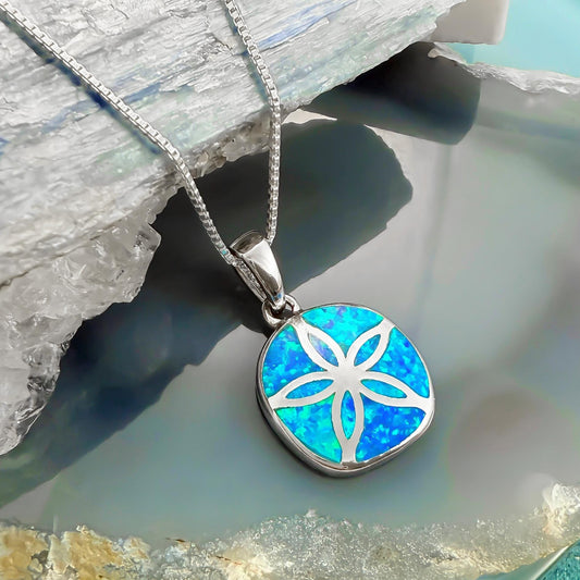 A silver necklace with a pendant featuring a blue opal flower design.
