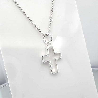 A silver cross pendant hanging from a chain.