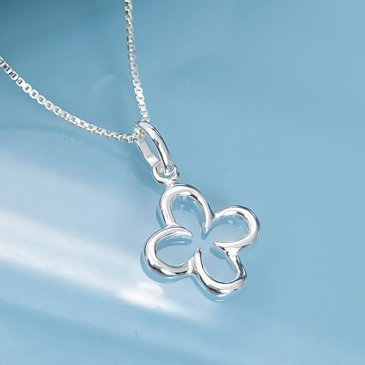 A silver flower pendant necklace with a chain is displayed against a blue background.