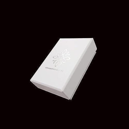 A white box with a silver flower design on it, set against a black background.