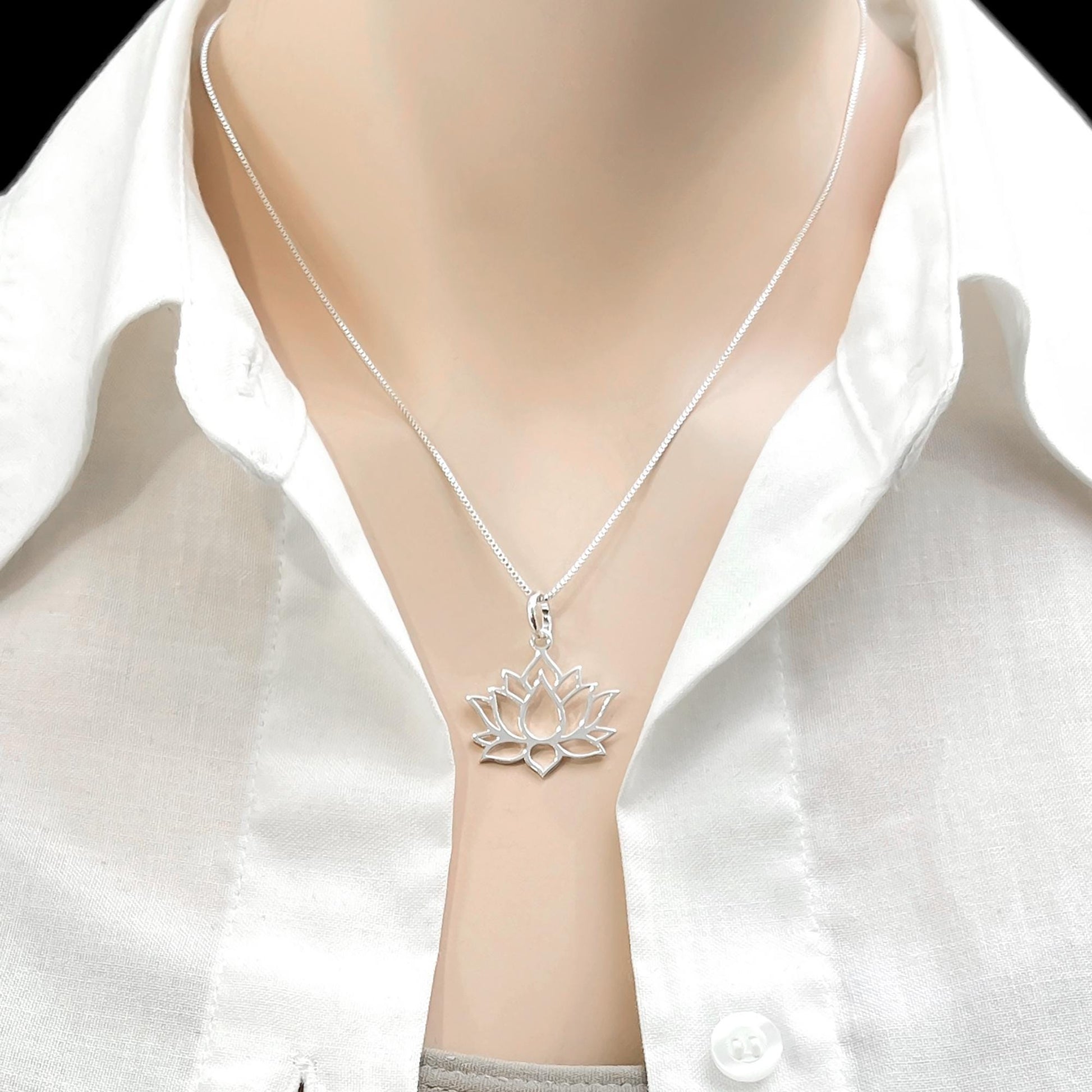 A silver necklace with a pendant featuring a lotus flower design.