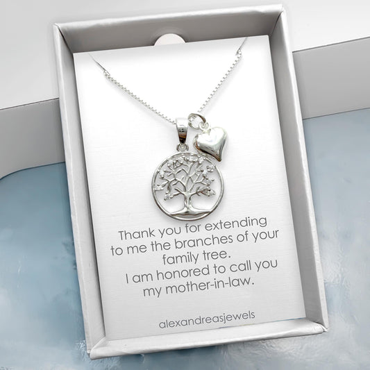 a silver necklace with a pendant and a heart charm, presented in a white box with a message expressing gratitude.
