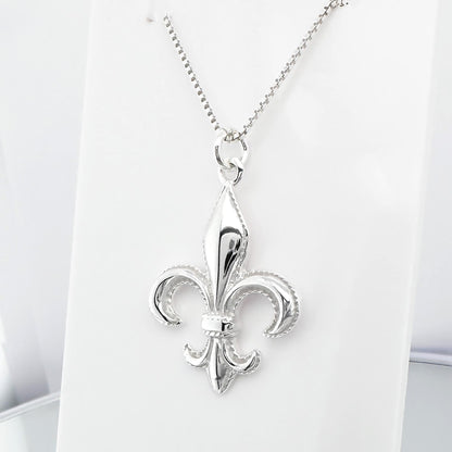 A silver-colored pendant necklace with a fleur-de-lis design.