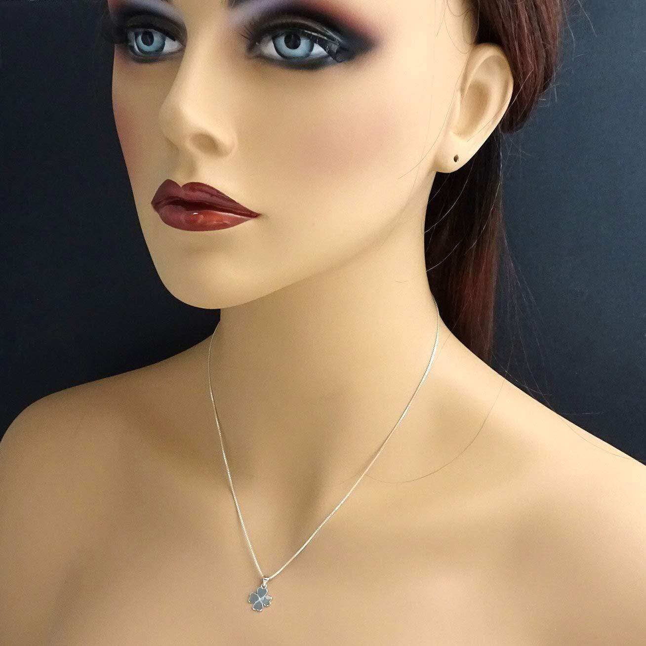 A mannequin head wearing a silver necklace with a pendant.