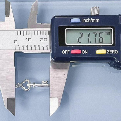 A digital caliper is being used to measure the size of a key chain, displaying the size as 2.7 inches.