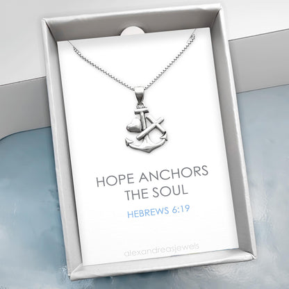 a silver necklace with an anchor pendant, presented in a white box with a blue background. The text on the box reads "HOPE ANCHORS THE SOUL" and "HEBREWS 6:19".