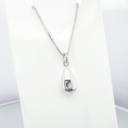 A silver necklace with a pendant is displayed on a white background.