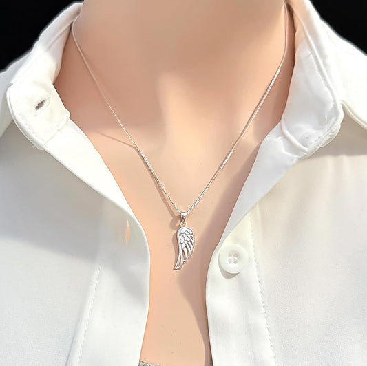 A silver necklace with a pendant featuring a wing design is shown against a white shirt collar.