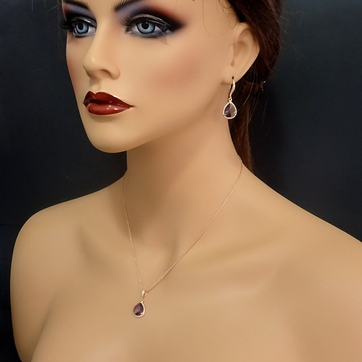 amethyst purple framed glass necklace and earrings in rose gold setting on a model mannequin