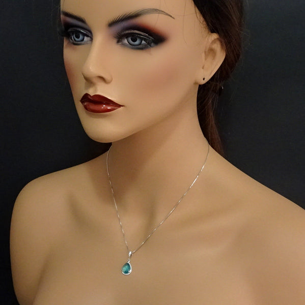 teal framed glass necklace on a model mannequin