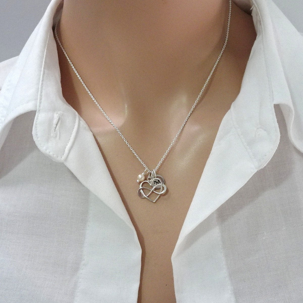 heart infinity necklace with ivory pearl and initial charm on a model mannequin