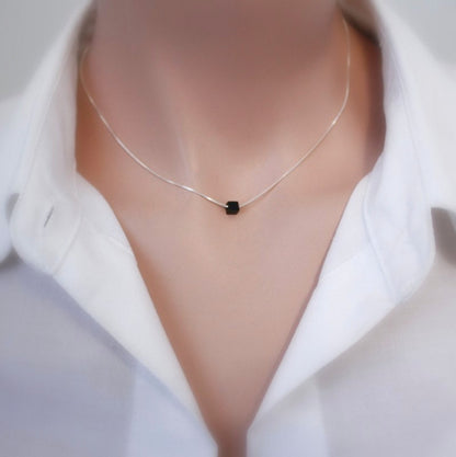 tiny black onyx cube necklace on a model mannequin