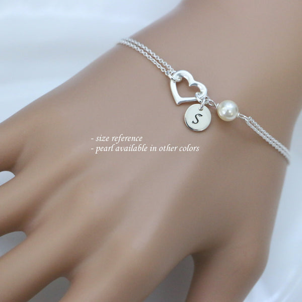 open heart and white pearl bracelet with initial charm on a model