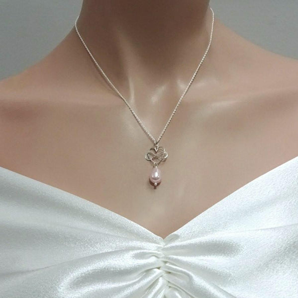 infinity heart and light pink pearl necklace on a model