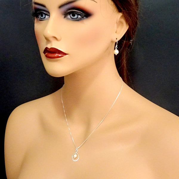 infinity and pearl necklace and earrings set on a model mannequin